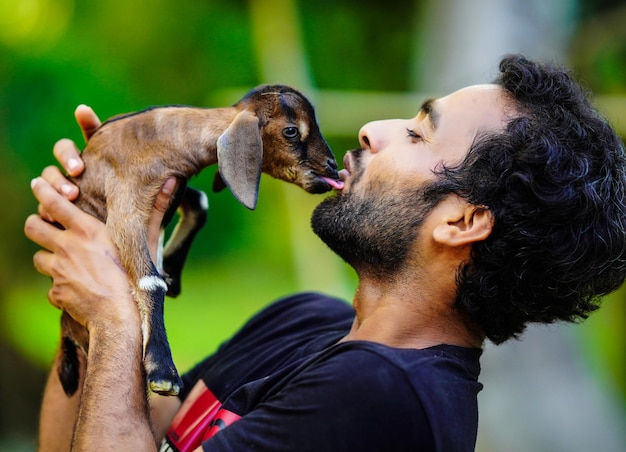 Foto menino com animal de estimação de cabra bebê fofo