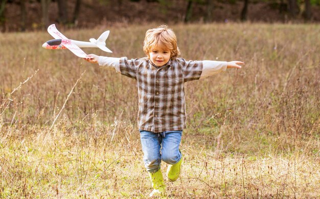 Menino com avião. Uma criança sonha em ser piloto.