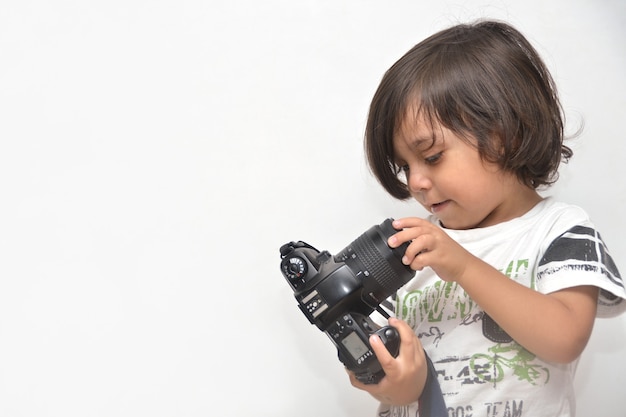 Menino com câmera fotográfica em fundo branco