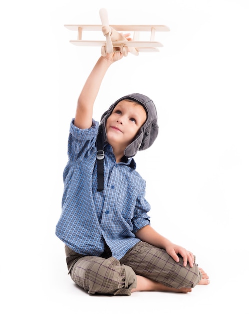 Foto menino com chapéu de piloto e avião de brinquedo