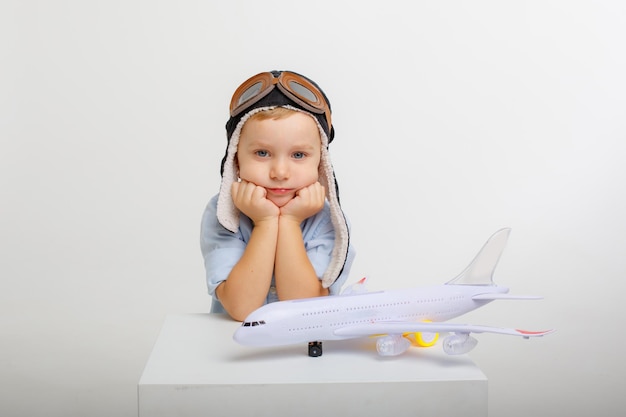 Menino com chapéu de piloto e um avião em um fundo branco