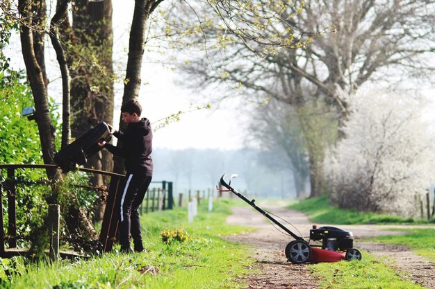 Menino com equipamento de jardinagem no caminho