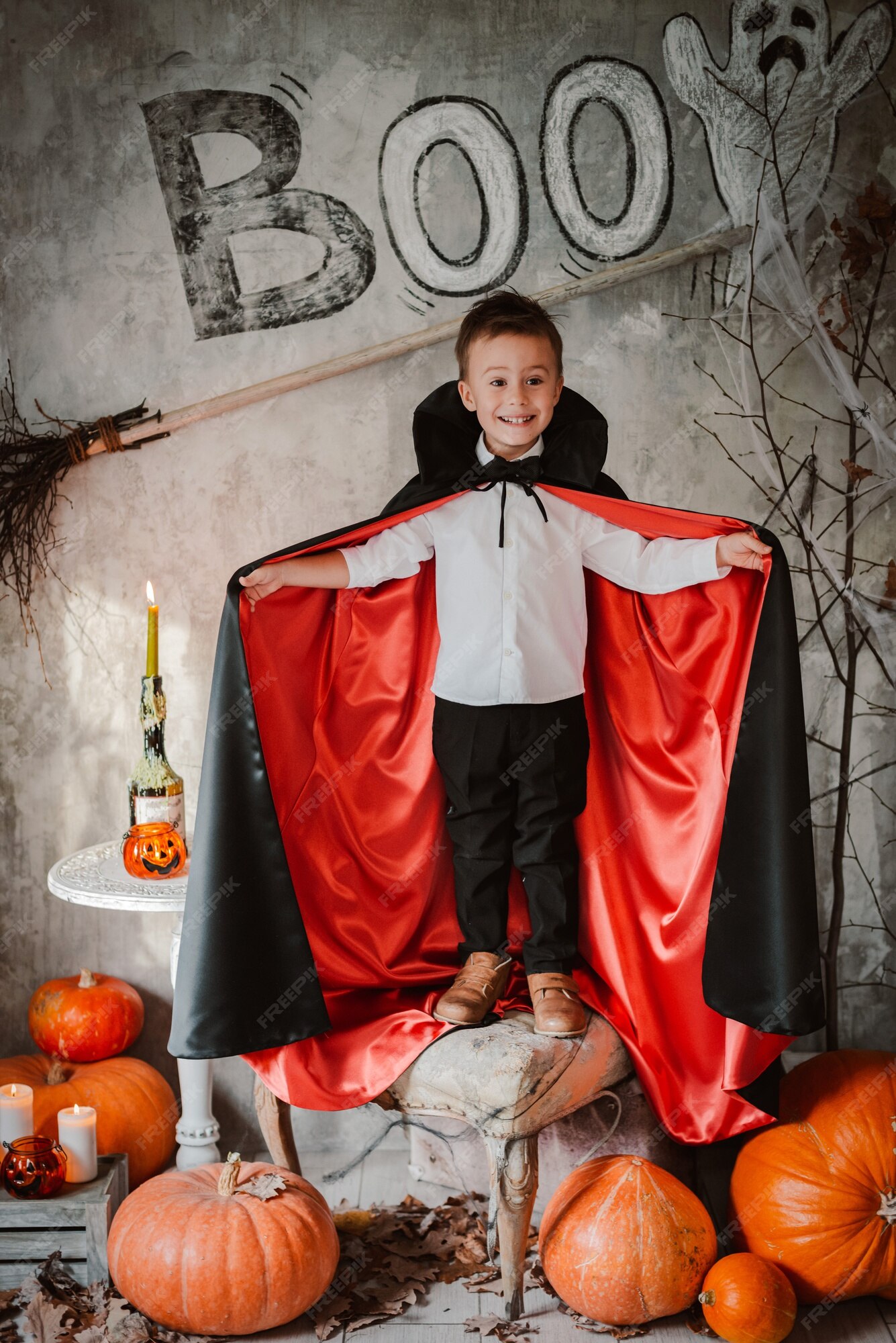 Um menino com uma fantasia de halloween fica em um campo.