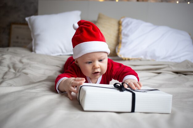 Menino com fantasia de Papai Noel em casa