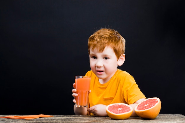 Menino com frutas cítricas