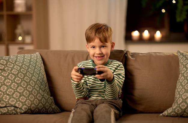 menino com gamepad jogando videogame em casa
