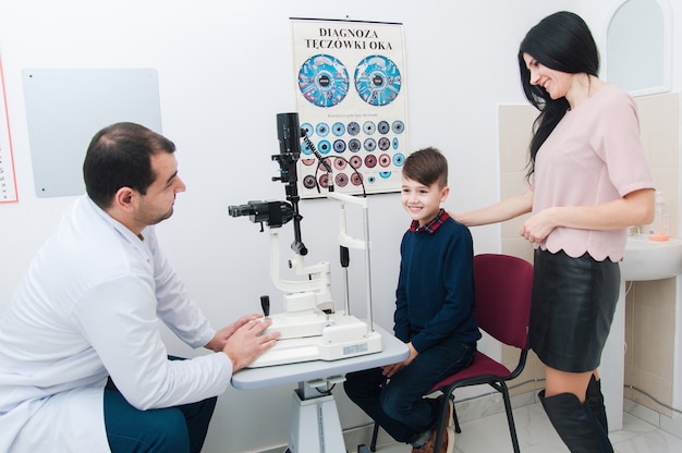 Foto menino com mãe em exame oftalmológico por oftalmologista