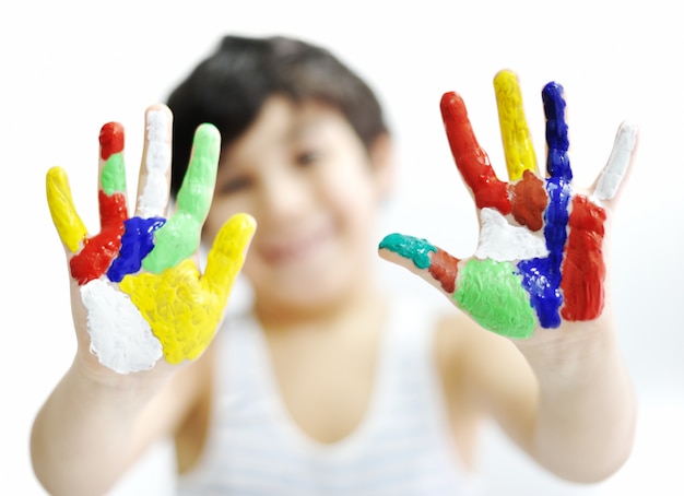 Menino com mãos pintadas em tintas coloridas prontas para impressões de mão