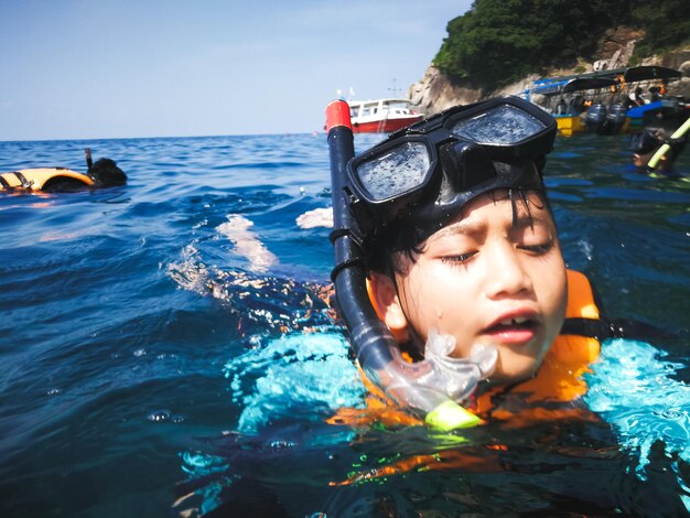 Foto menino com máscara de mergulho a nadar no mar