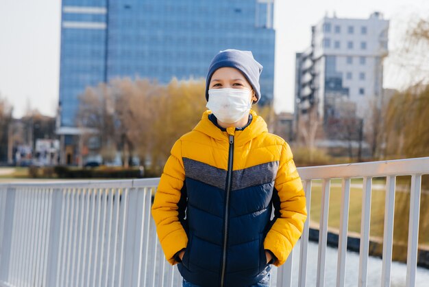 Menino com máscara facial andando nas ruas. Prevenção contra coronavírus