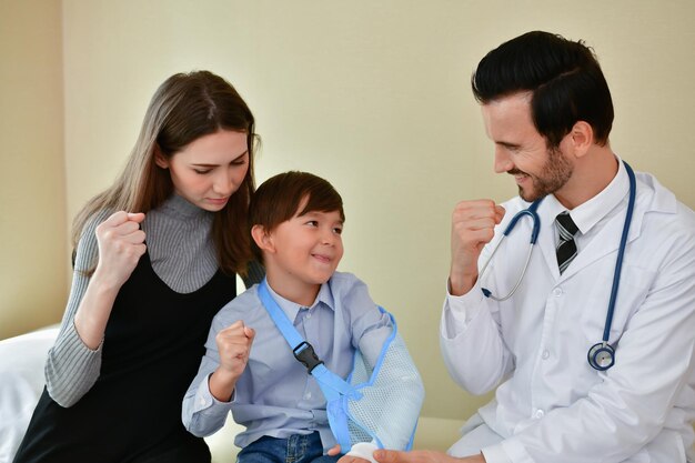 Foto menino com médico e mulher com mão fraturada mostrando punhos no hospital