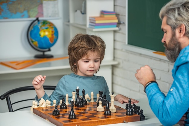 Menino com pai ensinando e aprendendo xadrez em casa Professor e criança Pai com filho jogando xadrez em casa