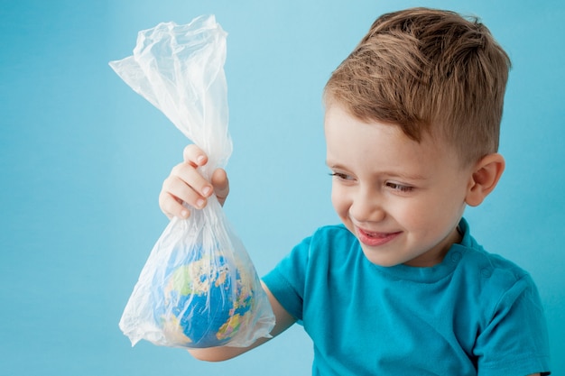 Menino com um globo em um pacote em um fundo azul