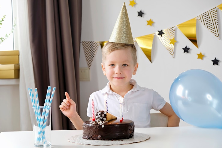 Foto menino comemorando aniversário soprando velas em um bolo