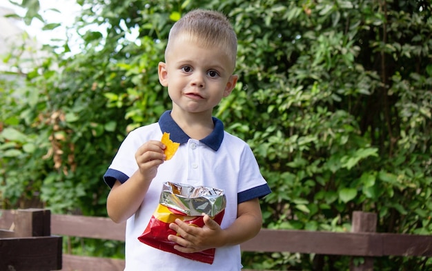 menino comendo batatas fritas foco seletivo natureza