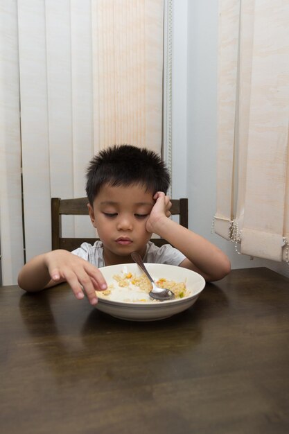 Foto menino comendo comida na mesa