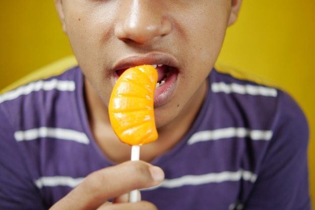 Menino comendo pirulito de perto