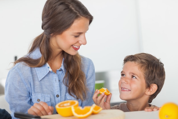 Menino comendo segmentos de laranja