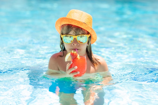 Menino criança bebendo coquetel de verão na piscina