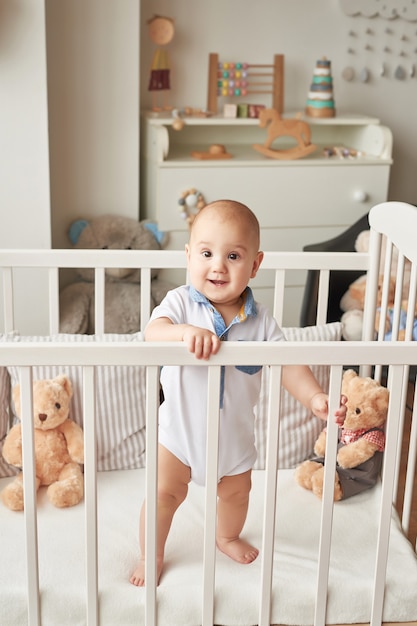 Foto menino criança brinca brinquedos de madeira em um quarto infantil em cores brilhantes, quarto infantil estilo escandinavo