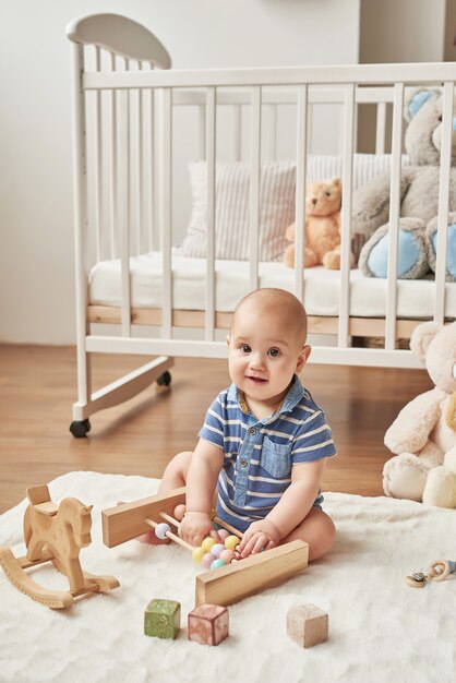 menino criança brinca brinquedos de madeira em um quarto infantil em cores brilhantes, quarto infantil estilo escandinavo
