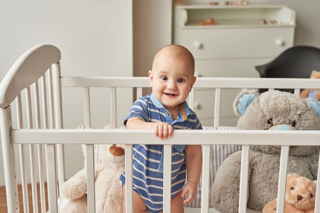 menino criança brinca brinquedos de madeira em um quarto infantil em cores brilhantes, quarto infantil estilo escandinavo