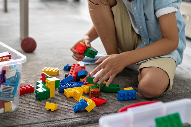 Menino criança brincando com blocos de plástico coloridos em casa construindo imaginação de jogo criativo