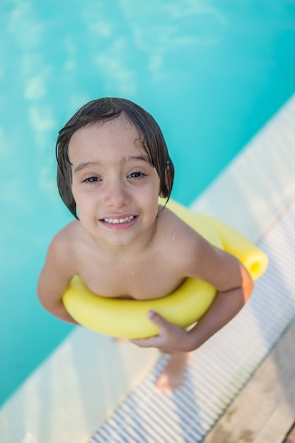 Foto menino criança criança espirrando na piscina se divertindo atividade de lazer