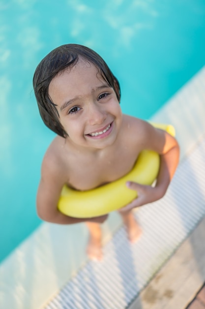 Menino criança criança espirrando na piscina se divertindo atividade de lazer