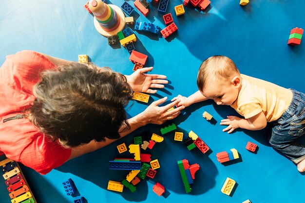 Menino criança e mãe brincando com um brinquedo educacional.