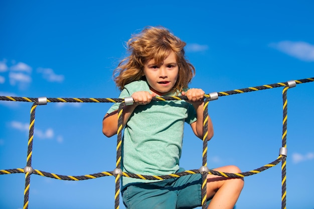 Menino criança feliz na web no playground ao ar livre Criança gostando de jogar atividades de verão crianças lazer recreação estilo de vida