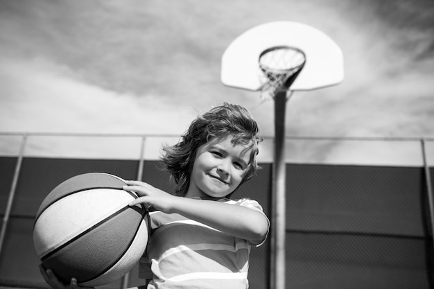 Menino criança jogando basquete com bola de basquete