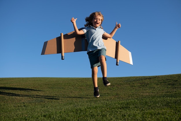 Menino criança sonha e viaja menino pulando e correndo com brinquedo de avião ao ar livre criança feliz brincando