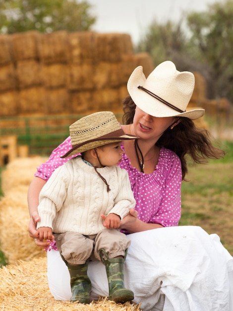 Menino da criança com sua mãe na fazenda.