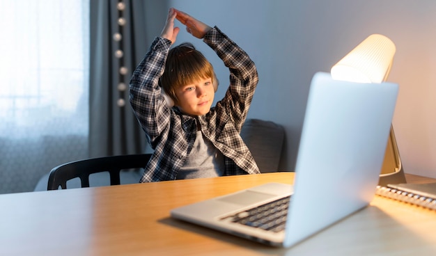 Foto menino da escola fazendo cursos online e gesticulando