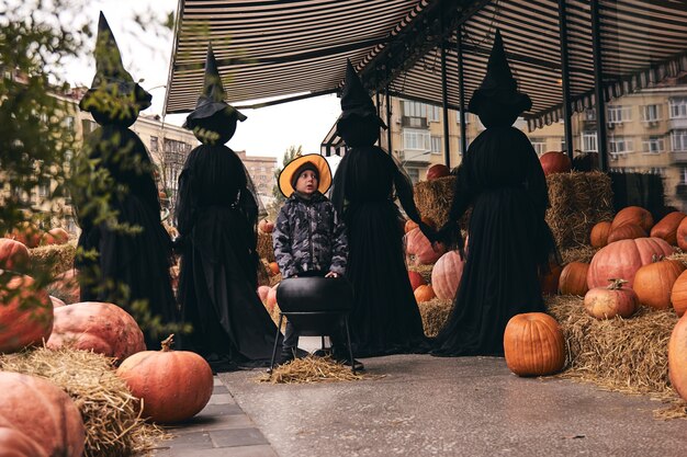 Um menino com uma fantasia de halloween fica em um campo.