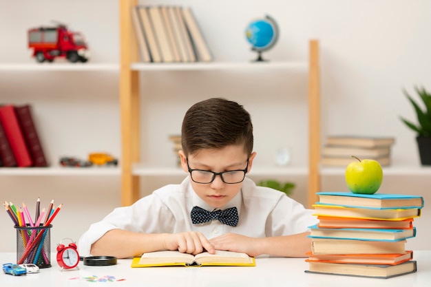 Foto menino de alto ângulo com óculos de leitura