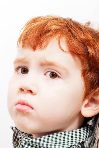 Menino de cabelo vermelho com uma expressão facial frustrada