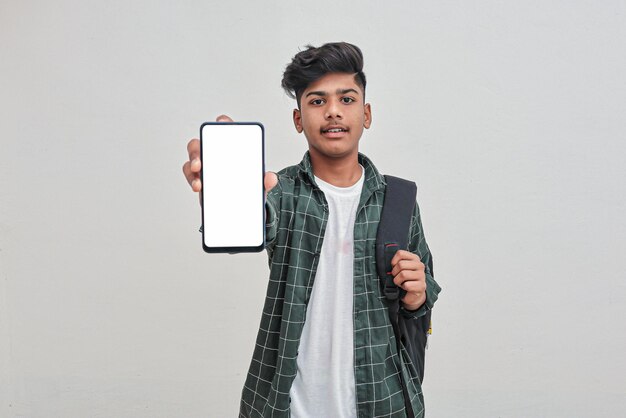 Menino de colagem indiano jovem mostrando a tela do smartphone em fundo branco