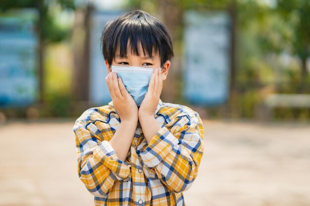Menino de crianças usando máscara para evitar poeira e vírus