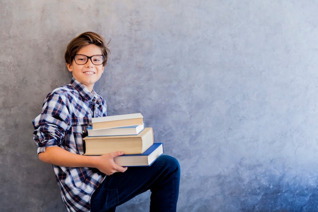 Menino de escola adolescente bonito segurando livros