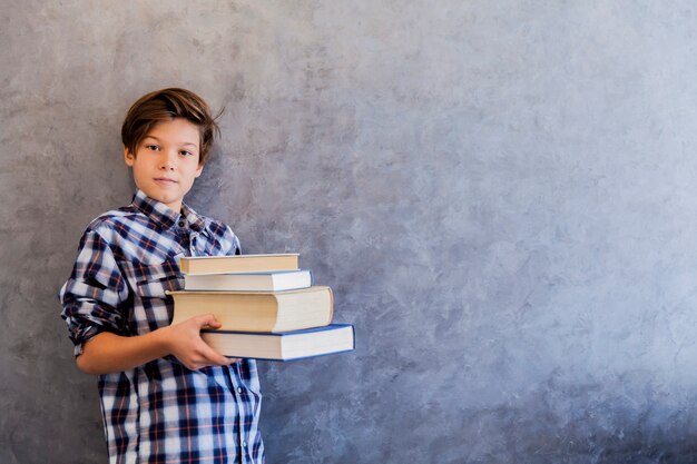 Menino de escola adolescente bonito segurando livros