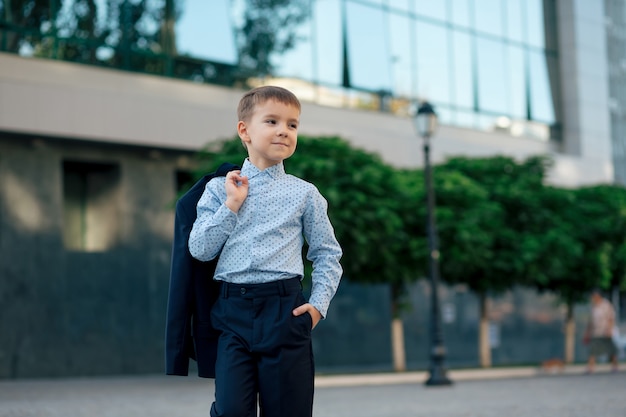 Menino de escola posando com roupa formal, roupas elegantes