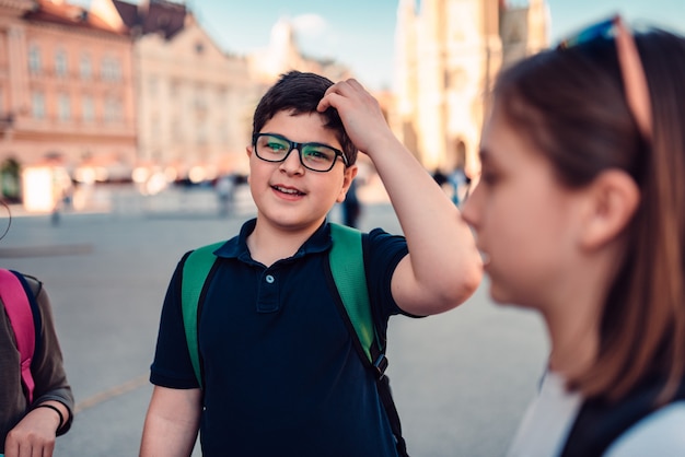 Menino de escola sair com amigos e coçar a cabeça