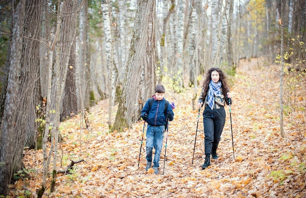 Menino de passeio nórdico e jovem mulher na floresta