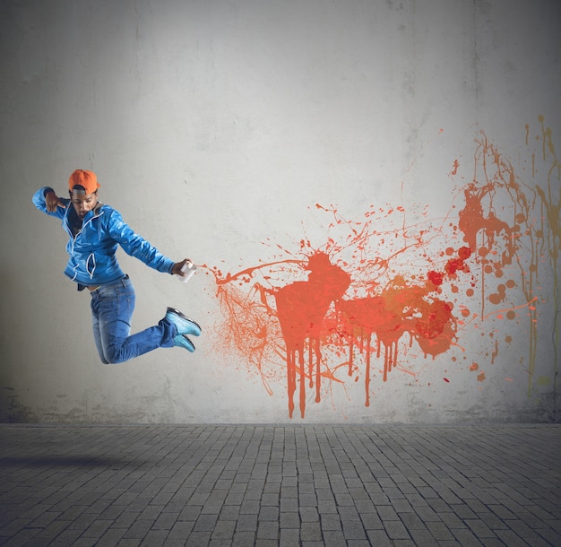 Menino de rua pintando paredes com spray