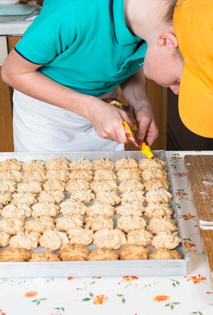 Foto menino decorando biscoitos de natal na mesa