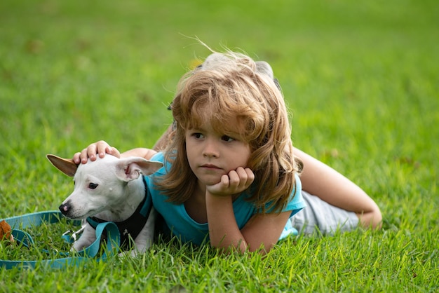 Menino deitado na grama com cachorro feliz dono de cachorrinho brincando com cachorrinho no gramado