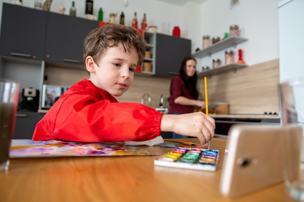 Menino desenha pinturas com aulas a distância on-line