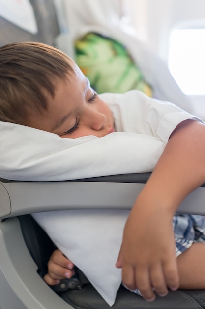 Menino dormindo dentro do avião durante o vôo